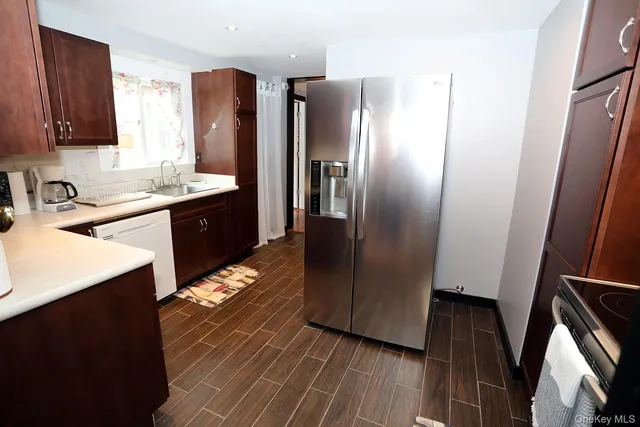 a kitchen with stainless steel appliances granite countertop a refrigerator a sink and wooden cabinets
