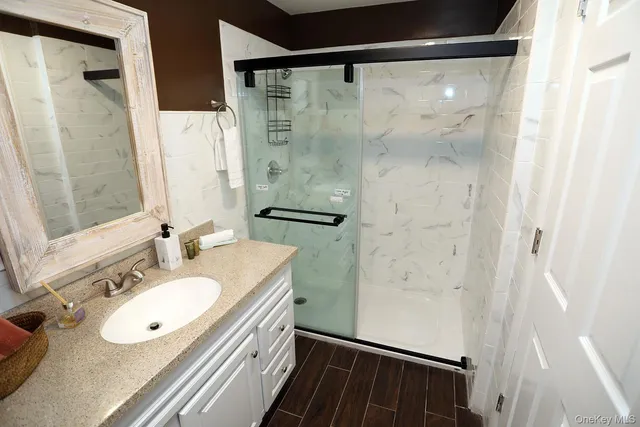 a bathroom with a sink vanity granite tub and shower