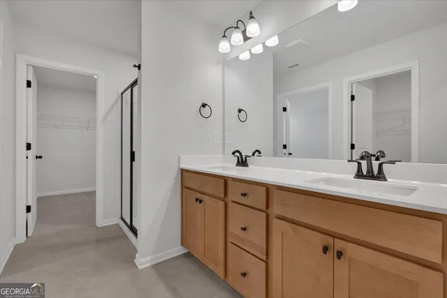 a bathroom with double vanity sinks a vanity a mirror and a shower