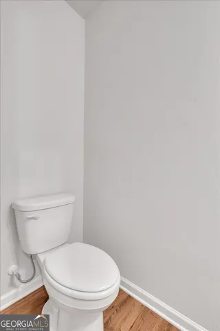 a white toilet sitting next to a white wall