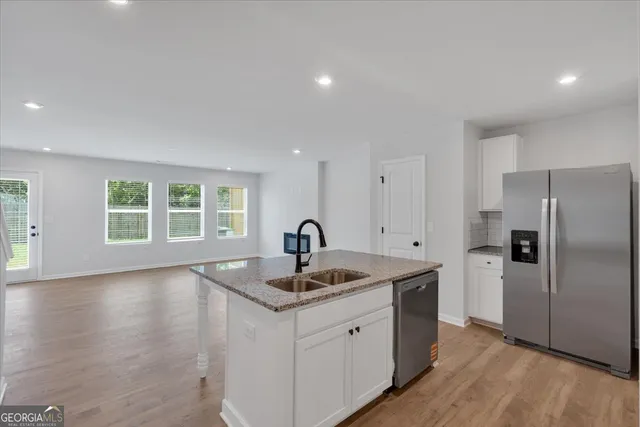 a kitchen with granite countertop a sink and a refrigerator