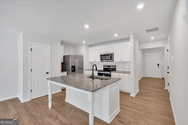 a kitchen with white cabinets and stainless steel appliances