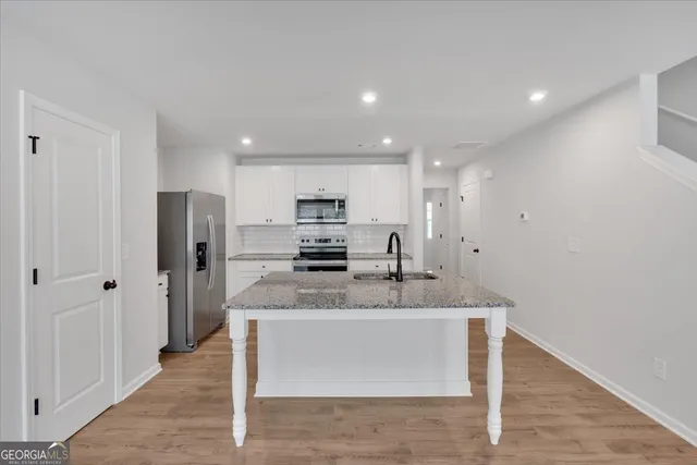 a large kitchen with stainless steel appliances lots of counter space and a sink