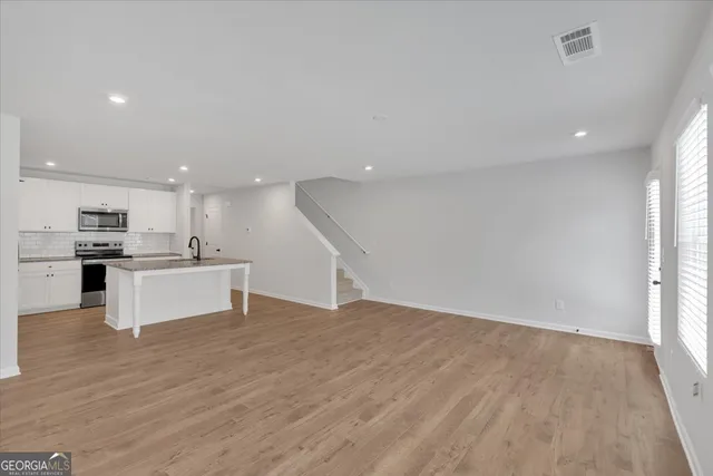 a view of kitchen with kitchen island white cabinets and refrigerator