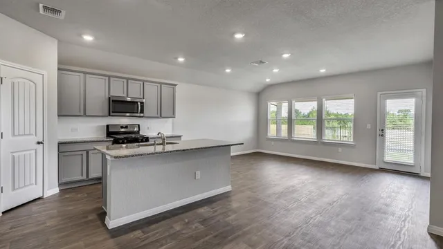 a kitchen with stainless steel appliances granite countertop a stove a sink and a refrigerator