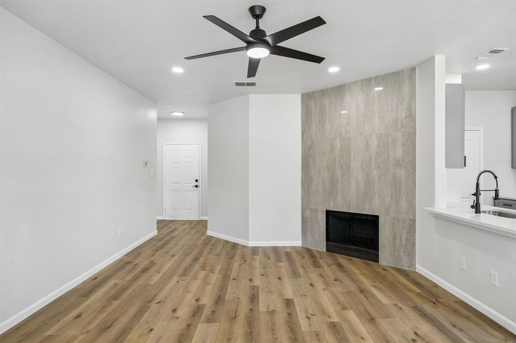 13347 Dove Ranch Road Fort Worth, TX 76262 - Photo 6 of 30 Wood-finish flooring, a contemporary ceiling fan, recessed lighting, and a tile-faced fireplace