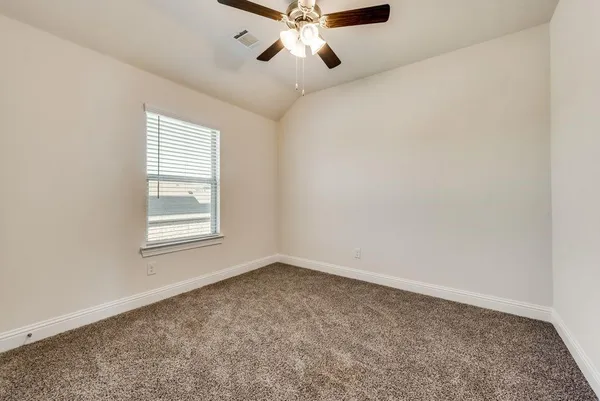 an empty room with a chandelier fan