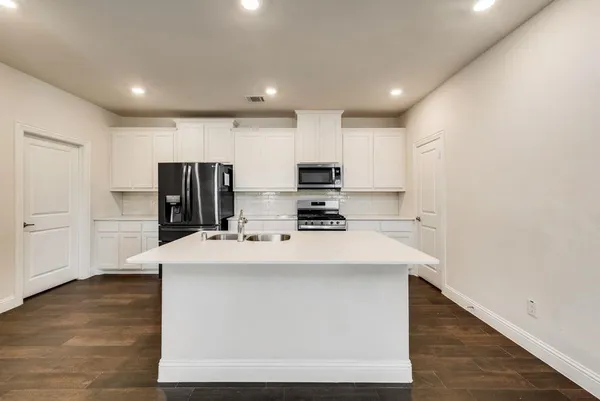 a kitchen with stainless steel appliances a refrigerator sink and microwave