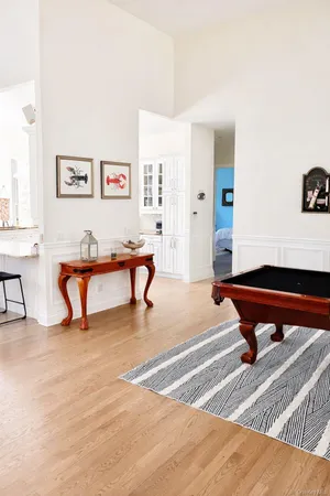 a room with furniture pool table and paintings on the wall