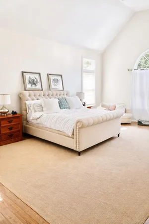 a bedroom with a bed lamp and a large window