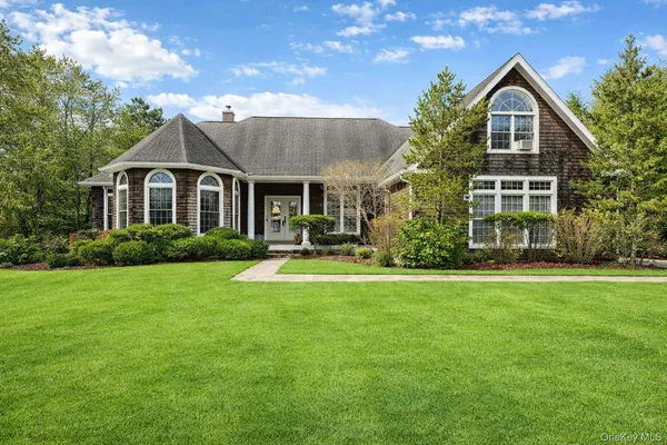 a front view of a house with a yard and trees