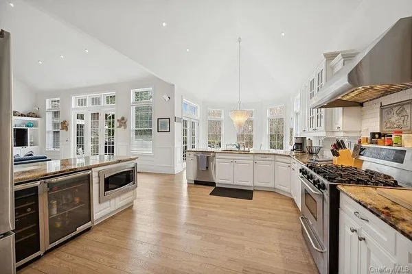a kitchen with stainless steel appliances a stove and wooden floor
