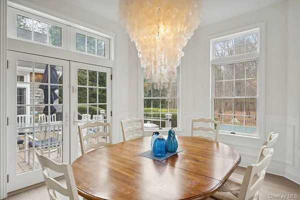 a view of a dining room with furniture a chandelier and wooden floor