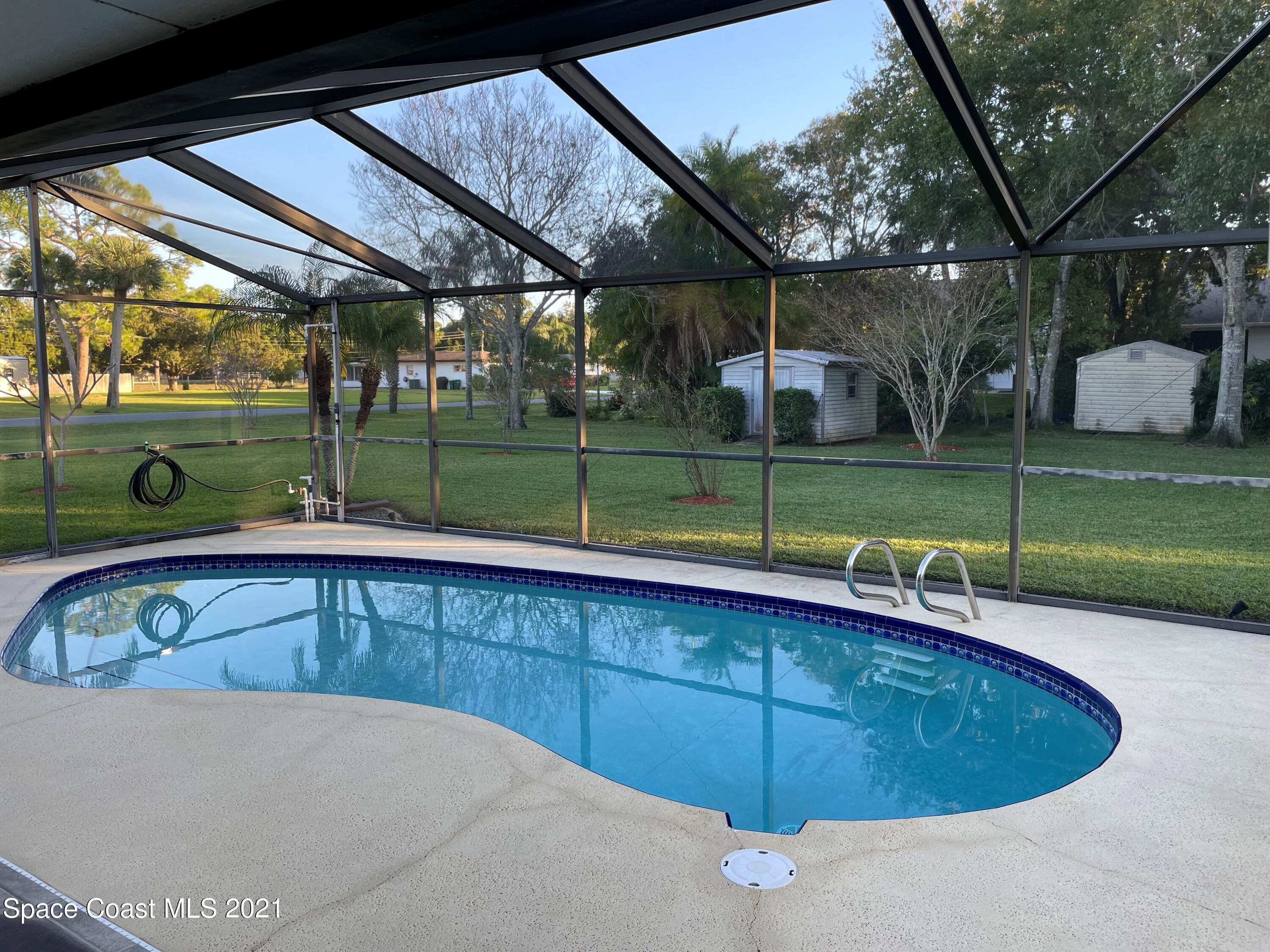 a view of a backyard with swimming pool
