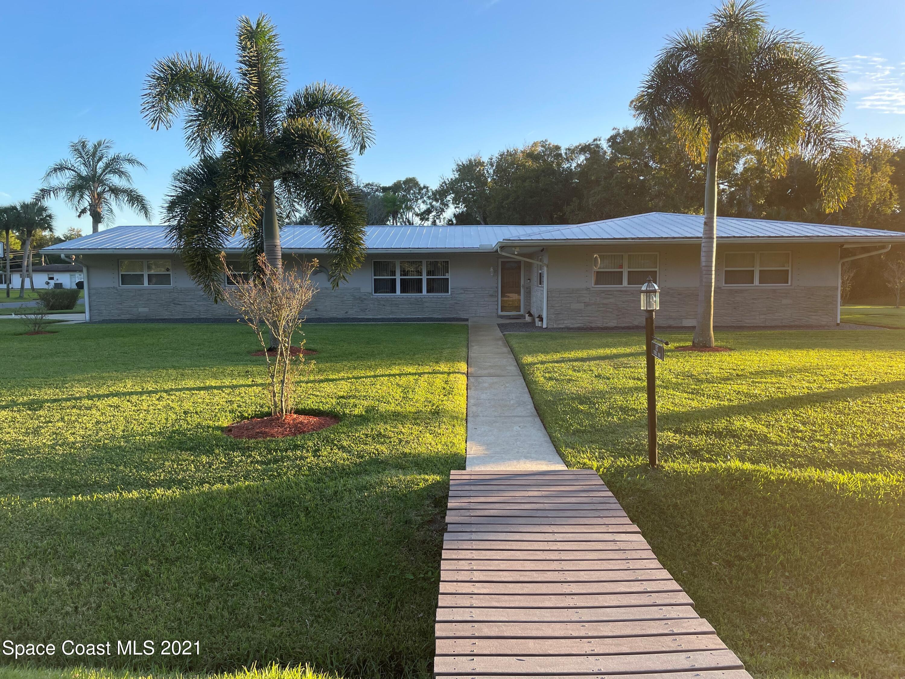 1937 Trimble Road Melbourne, FL 32934 - Photo 2 of 7 a view of a swimming pool with a garden