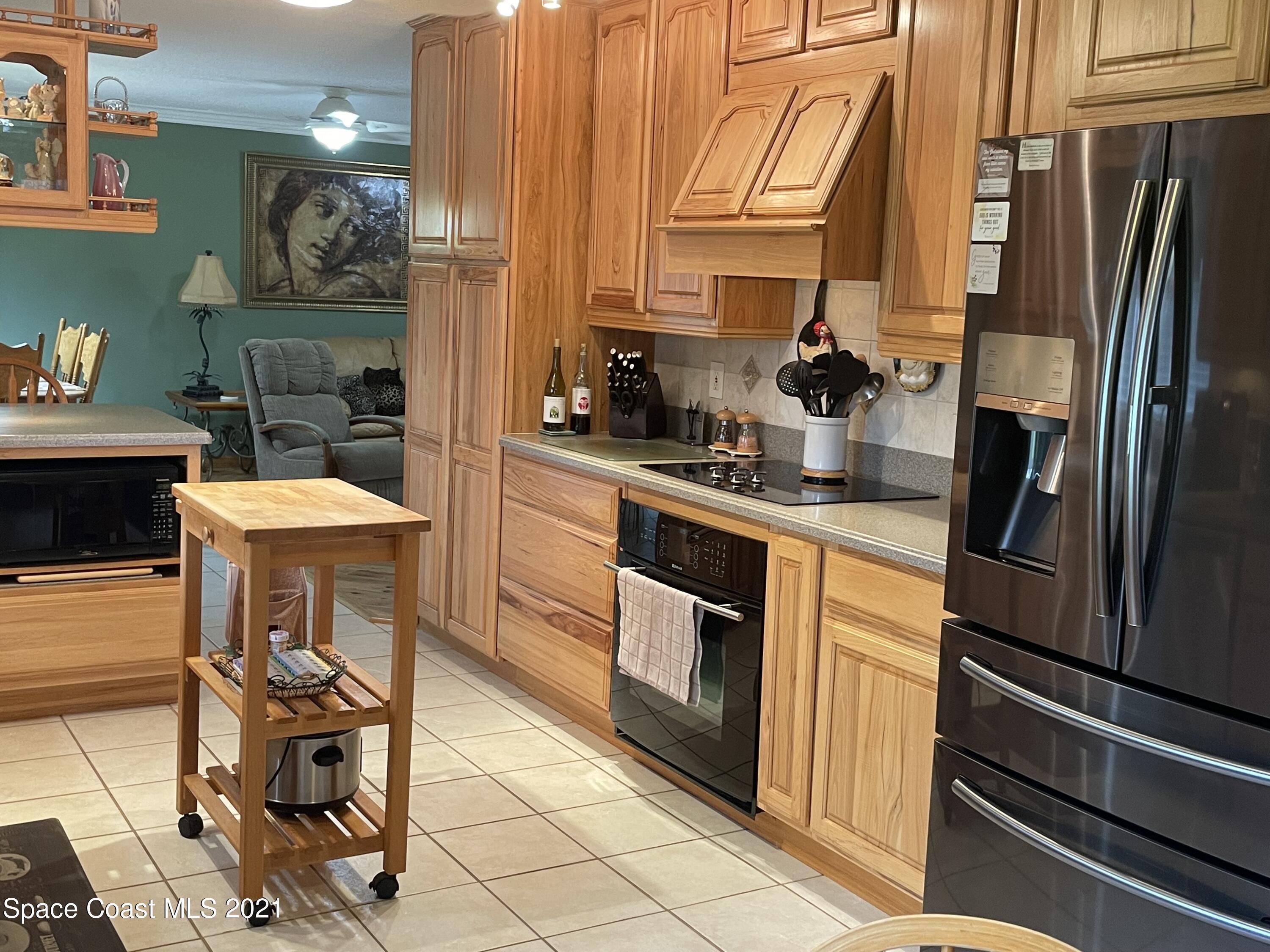 1937 Trimble Road Melbourne, FL 32934 - Photo 3 of 7 a kitchen with stainless steel appliances granite countertop a sink and a refrigerator