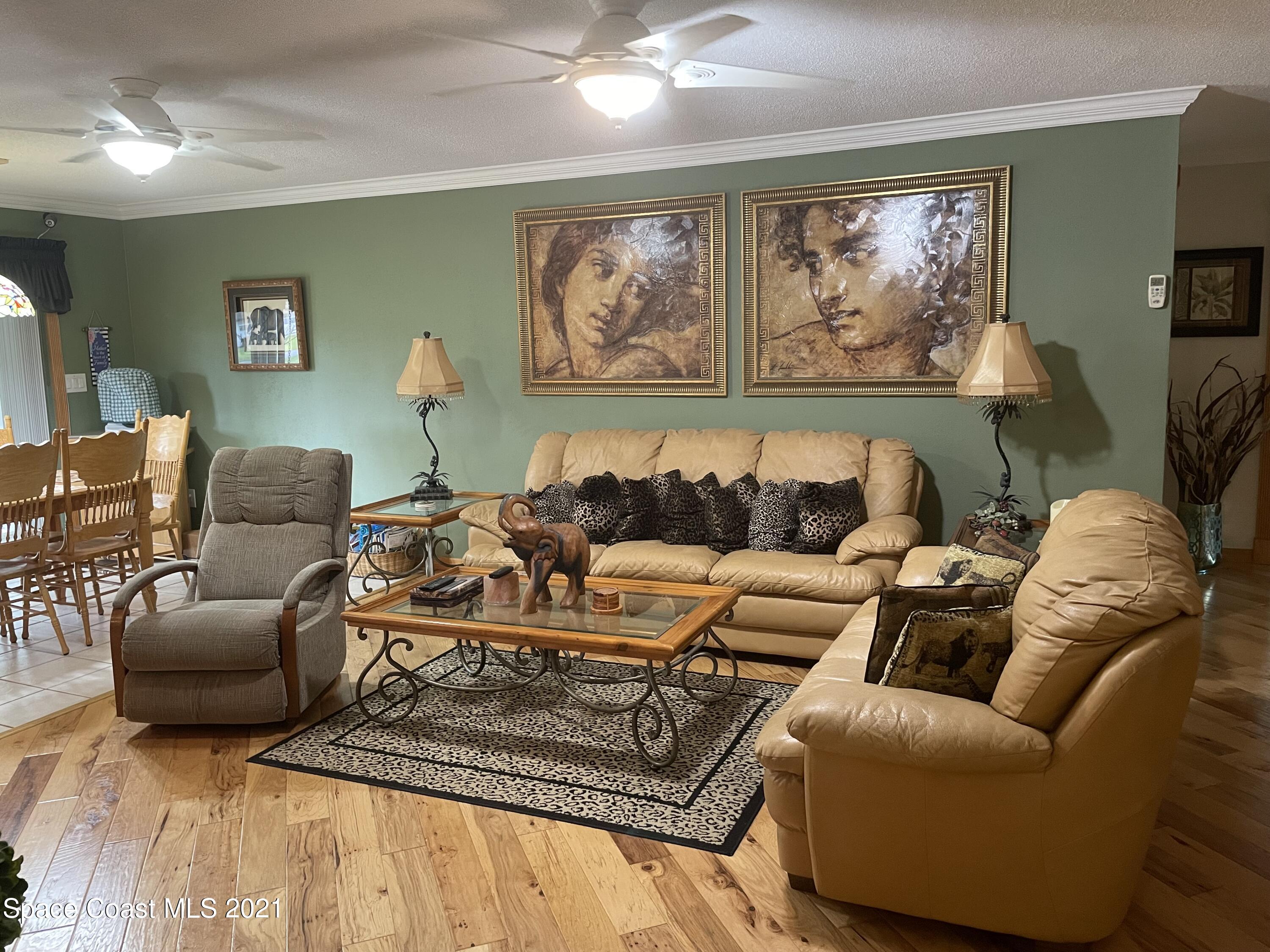 1937 Trimble Road Melbourne, FL 32934 - Photo 7 of 7 a living room with furniture a couch and paintings on the wall