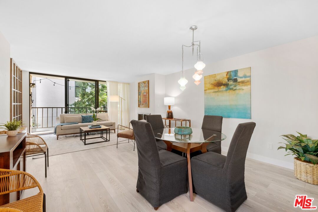 10966 Rochester Avenue, Unit 3F Los Angeles, CA 90024 - Photo 3 of 11 a dining room with furniture a chandelier and wooden floor