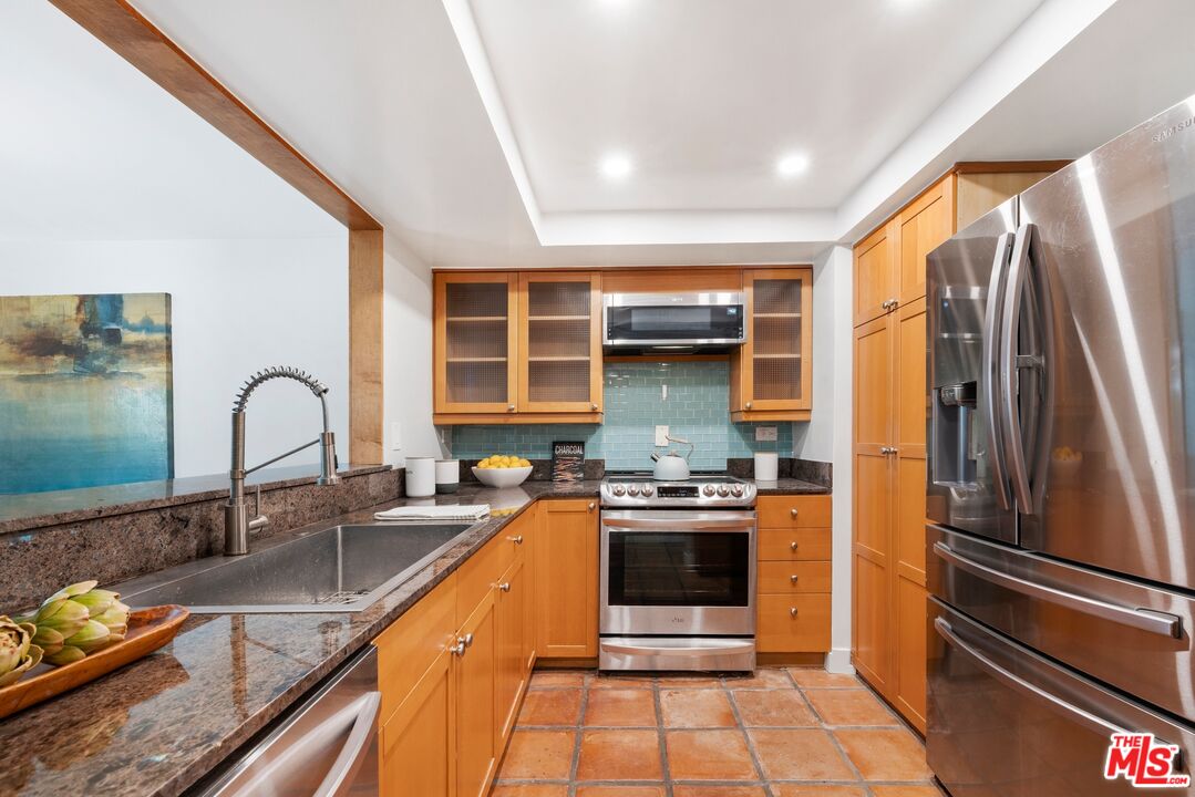 10966 Rochester Avenue, Unit 3F Los Angeles, CA 90024 - Photo 4 of 11 a kitchen with stainless steel appliances granite countertop a sink stove and refrigerator