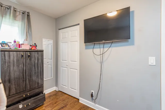 a view of a livingroom with wooden floor and cabinet