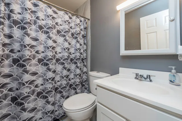 a bathroom with a sink toilet and a mirror