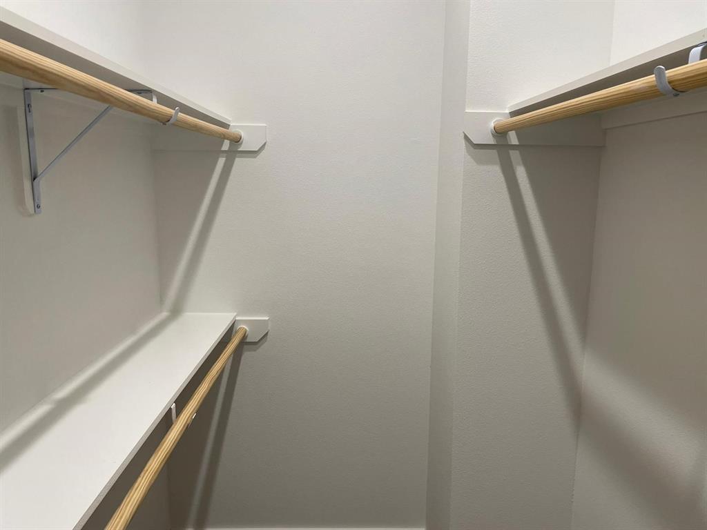 9114 Caddo Road, Unit A & B Houston, TX 77078 - Photo 21 of 24 Walk-in closet featuring white painted walls, white shelving, and natural wood clothing rods