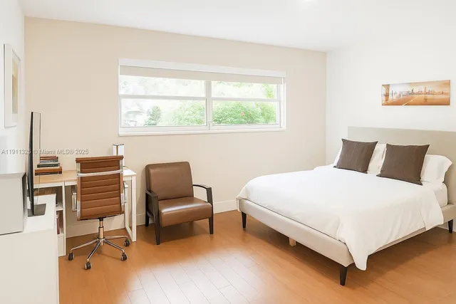 a bedroom with a bed chair and window