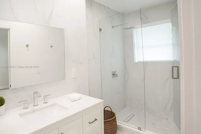 a bathroom with a shower sink vanity and mirror