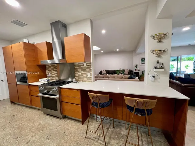 a kitchen with stainless steel appliances a sink a stove a counter top space and cabinets