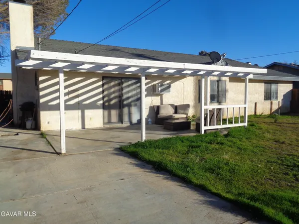 a view of a house with backyard and sitting area
