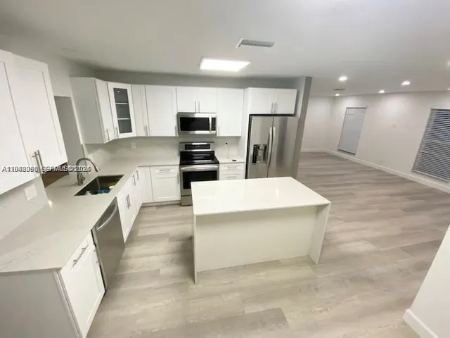 a kitchen with stainless steel appliances a refrigerator sink and microwave