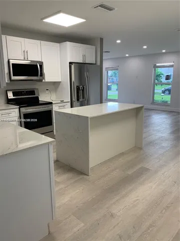 a kitchen with refrigerator and microwave