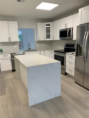 a kitchen with stainless steel appliances a refrigerator stove microwave and sink