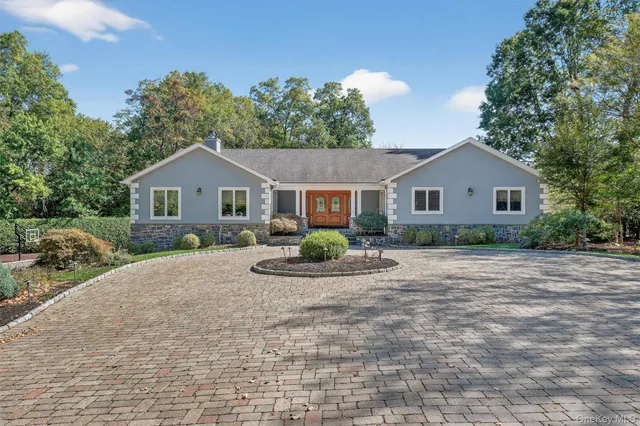 a front view of a house with a yard outdoor seating and garage