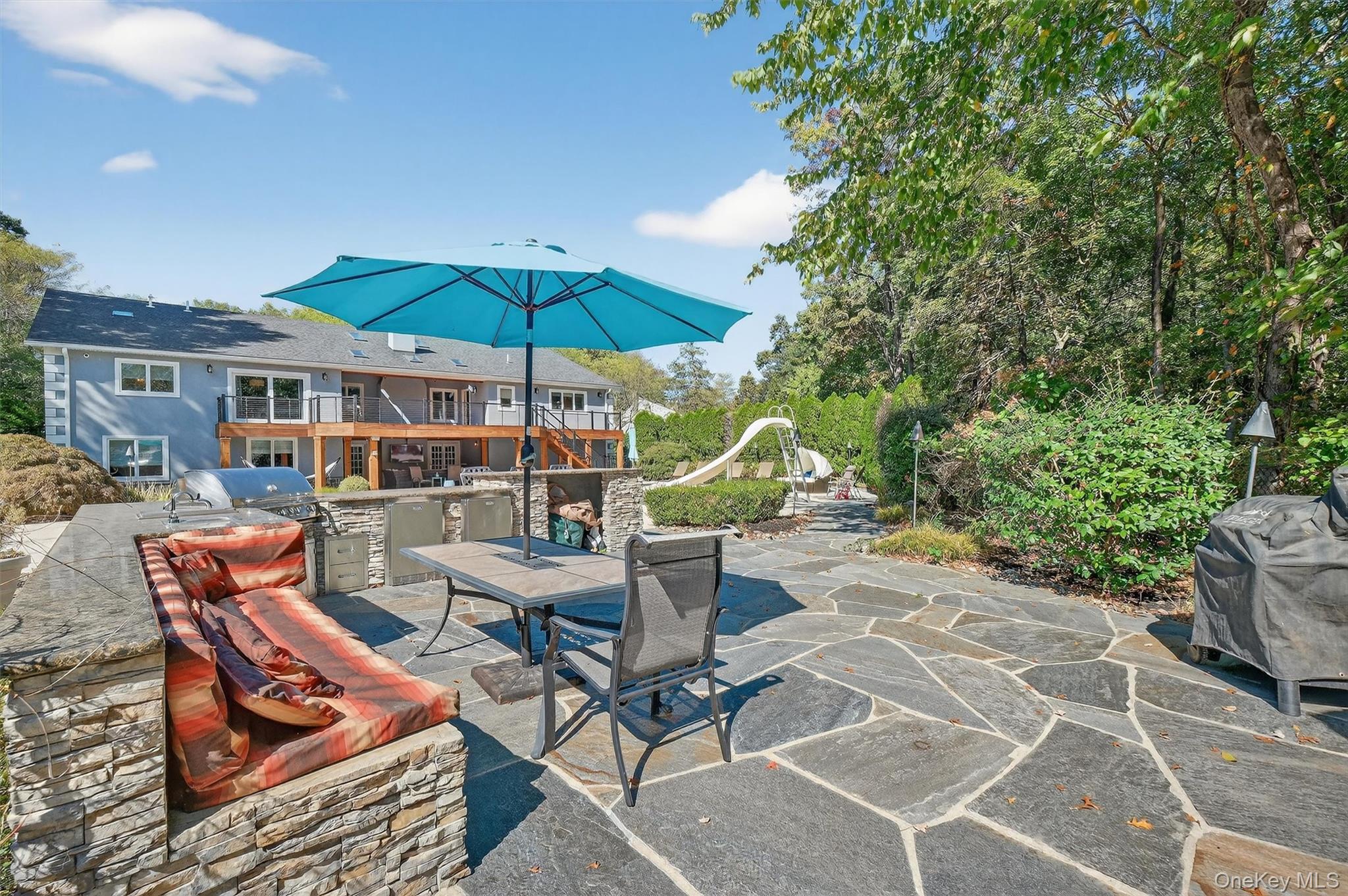 5 Stonehaven Road West Nyack, NY 10994 - Photo 42 of 50 a view of a patio with a dining table and chairs under an umbrella
