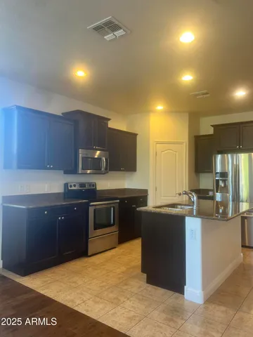 a large kitchen with stainless steel appliances and a sink
