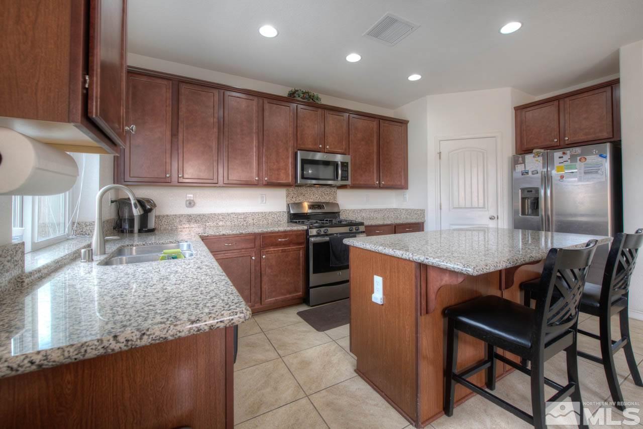2180 Hope Valley Drive Reno, NV 89521 - Photo 8 of 21 a kitchen with stainless steel appliances granite countertop wooden cabinets a stove top oven a sink and dishwasher