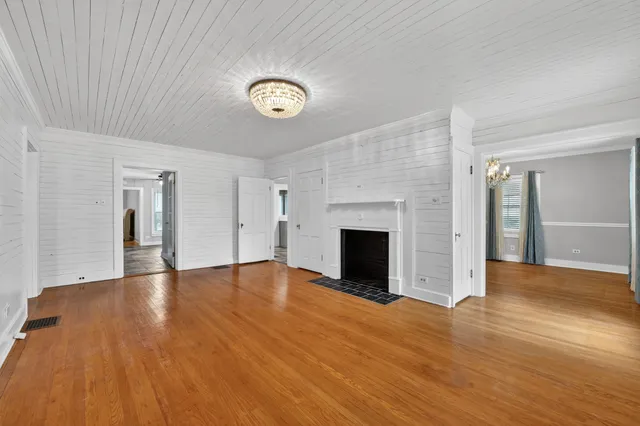 a view of empty room with wooden floor and fireplace