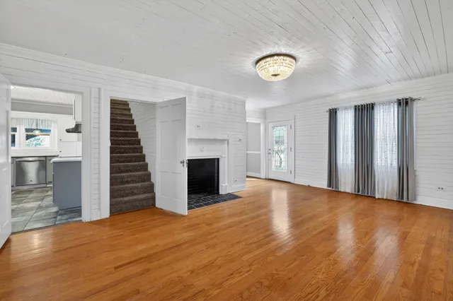 a view of a livingroom with wooden floor and staircase