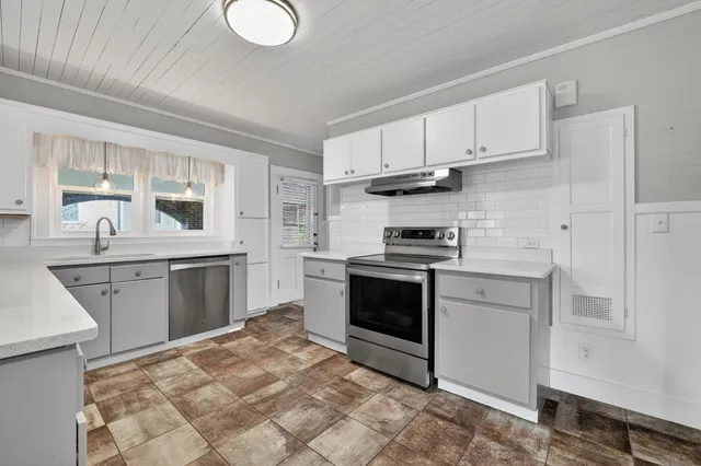 a kitchen with a stove sink and cabinets