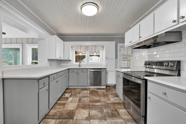 a kitchen with a stove sink and cabinets