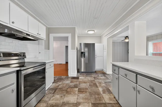 a kitchen with stainless steel appliances granite countertop a stove a sink and a refrigerator