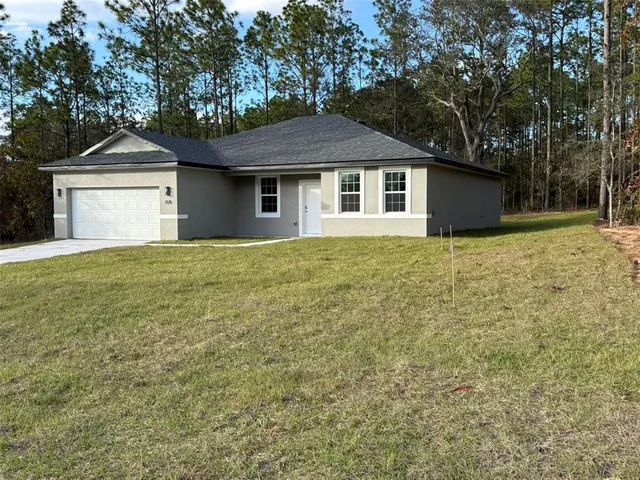 a view of kitchen with refrigerator and white cabinets