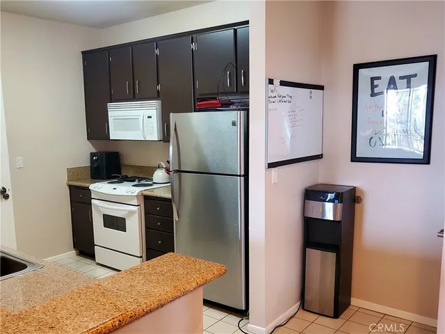 a kitchen with a refrigerator sink and cabinets