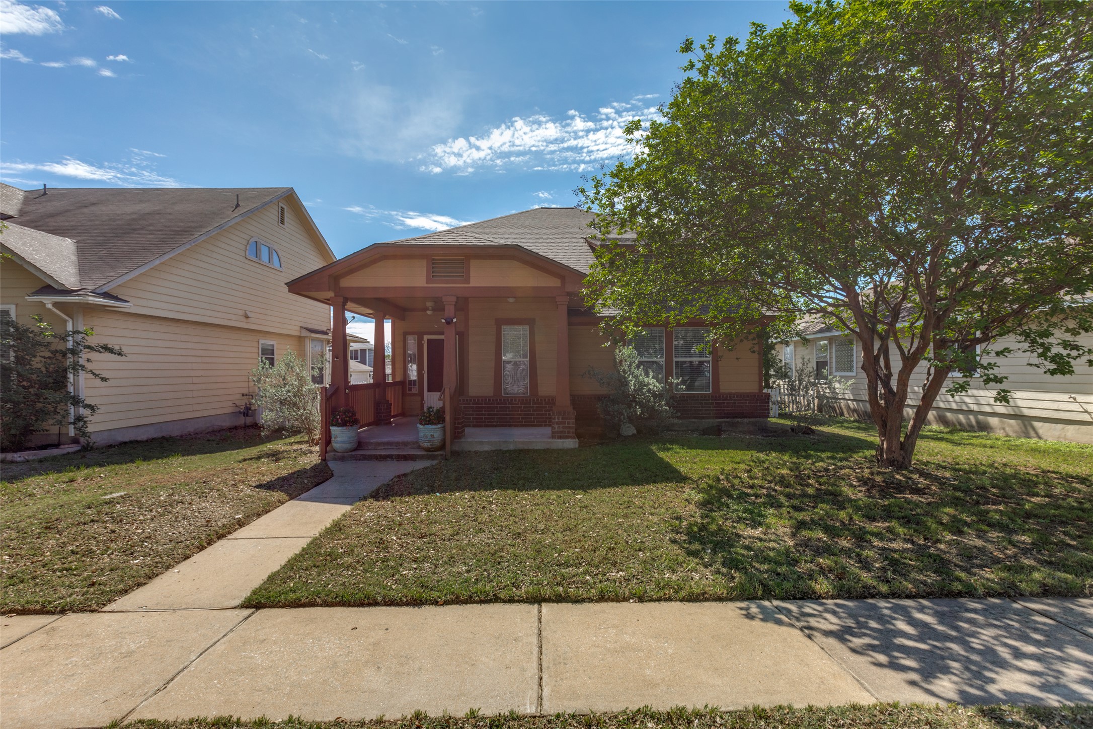 View of front facade with a front yard, a porch, and brick siding
