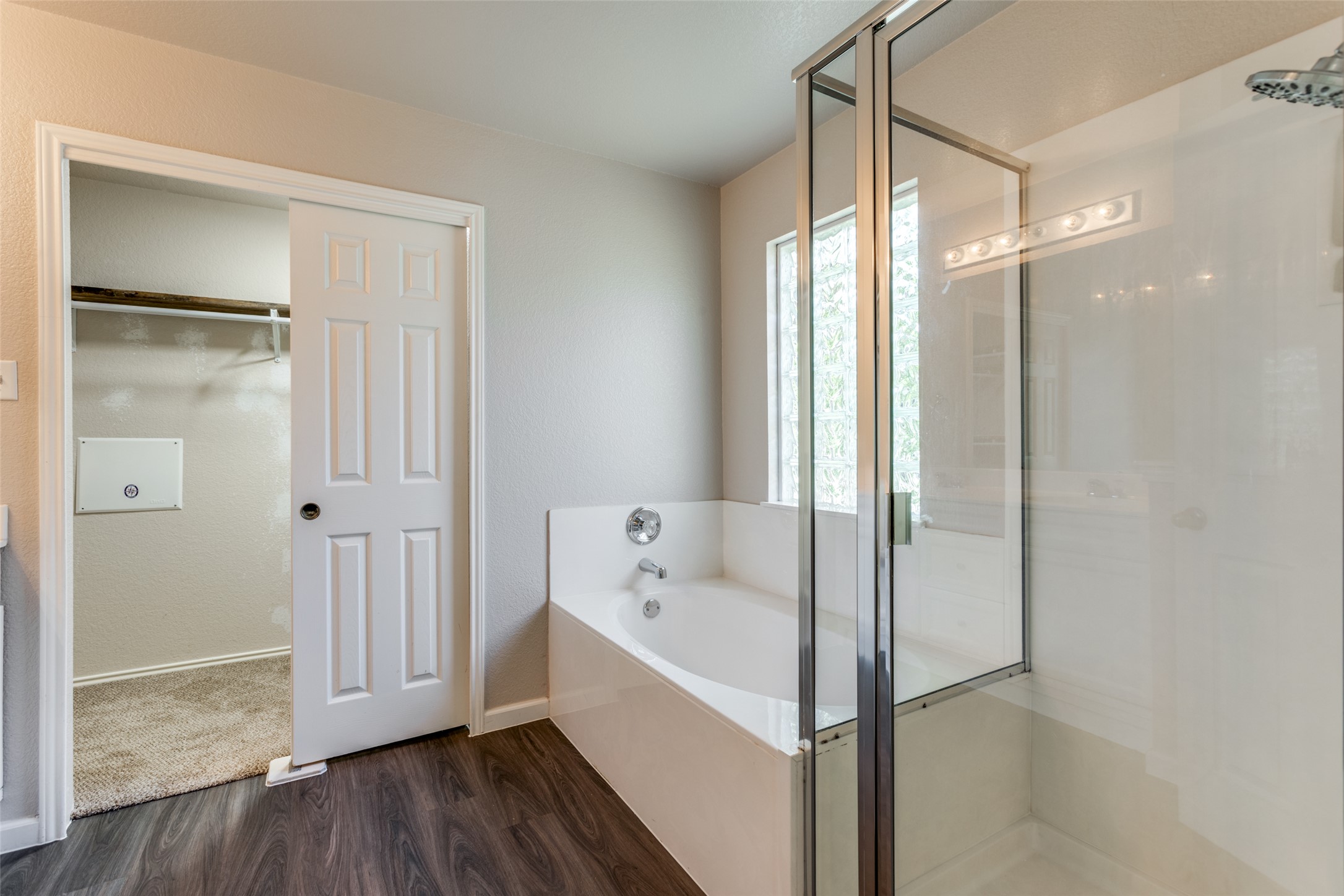 5043 Hartson Kyle, TX 78640 - Photo 15 of 30 Full bath with a garden tub, double sinks, dark wood-style finished floors, and a stall shower