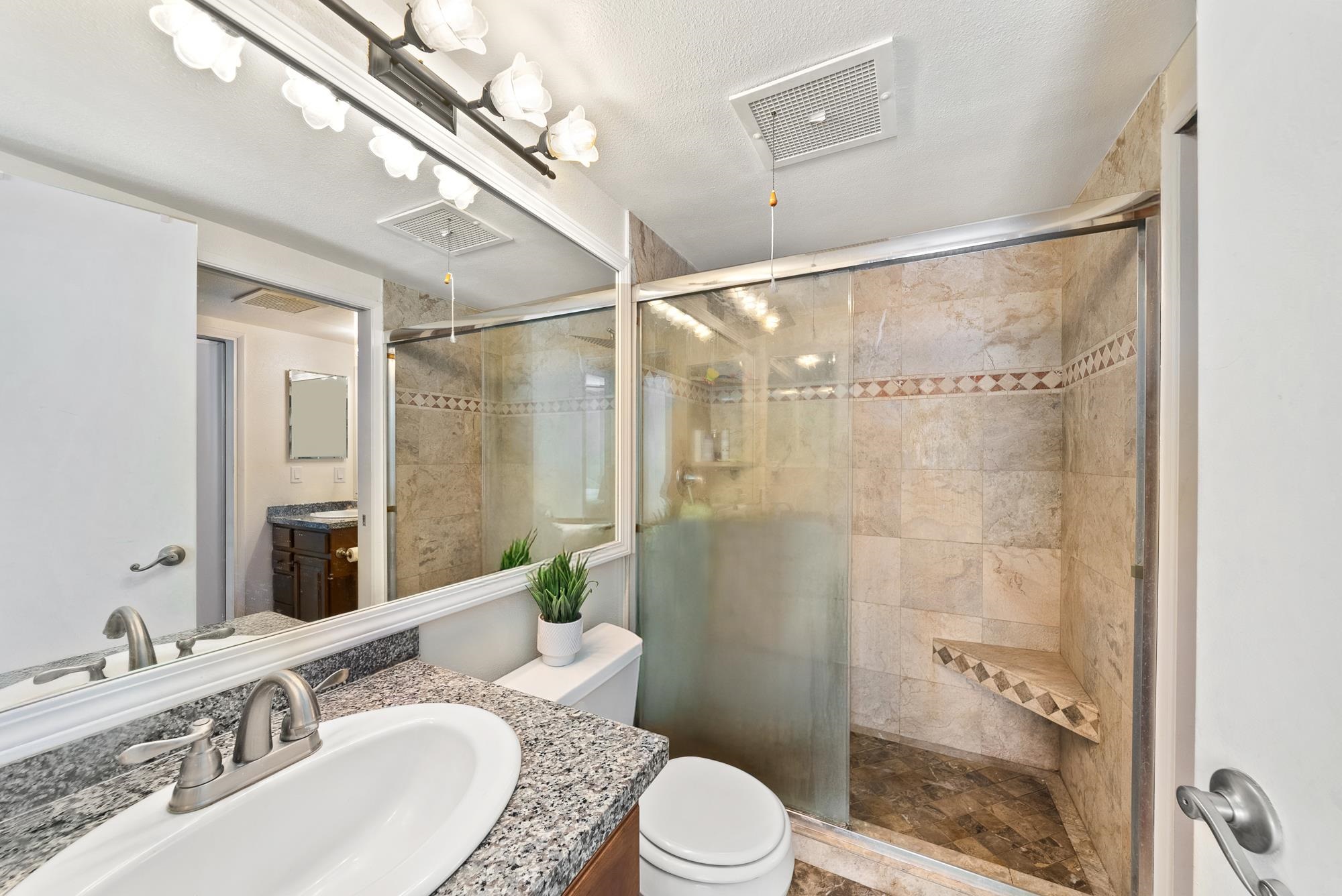 160 Keonekai Road, Unit 9101 Kihei, HI 96753 - Photo 12 of 23 a bathroom with a granite countertop sink toilet a mirror and shower