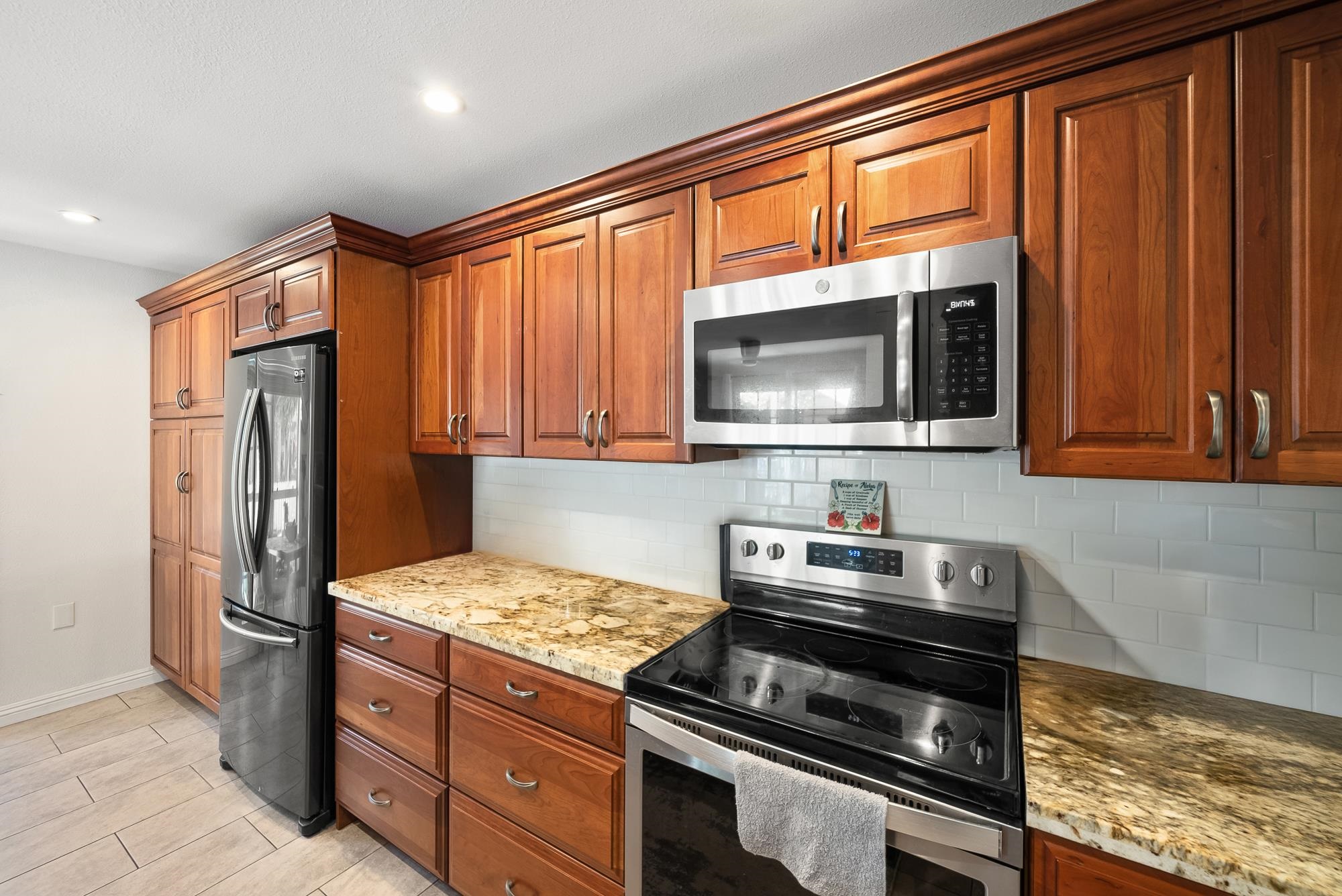 160 Keonekai Road, Unit 9101 Kihei, HI 96753 - Photo 3 of 23 a kitchen with stainless steel appliances granite countertop a refrigerator stove and microwave