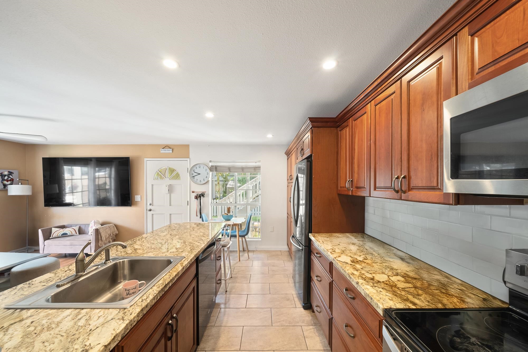 160 Keonekai Road, Unit 9101 Kihei, HI 96753 - Photo 5 of 23 a kitchen with granite countertop a sink and a stove top oven with wooden floor