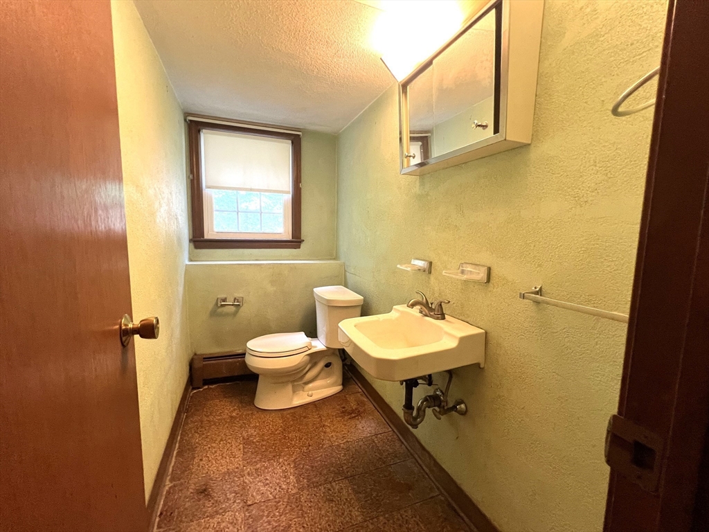31 Dix Rd Extension Woburn, MA 01801 - Photo 18 of 22 a bathroom with a toilet a sink and mirror